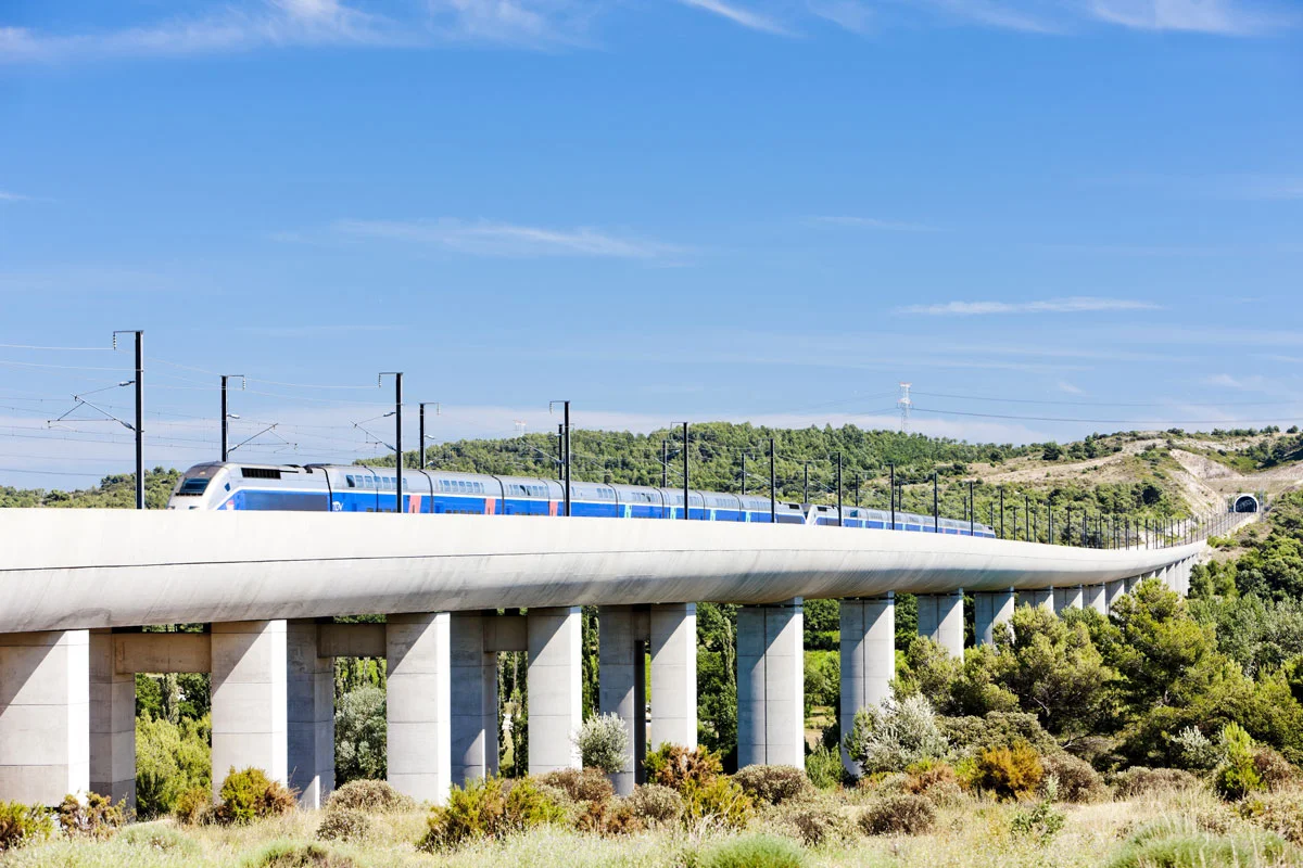 TGV traversant un viaduc ferroviaire au-dessus d'une forêt près de Vernegues, Provence, en direction de la Gare TGV d'Avignon dans le Vaucluse.