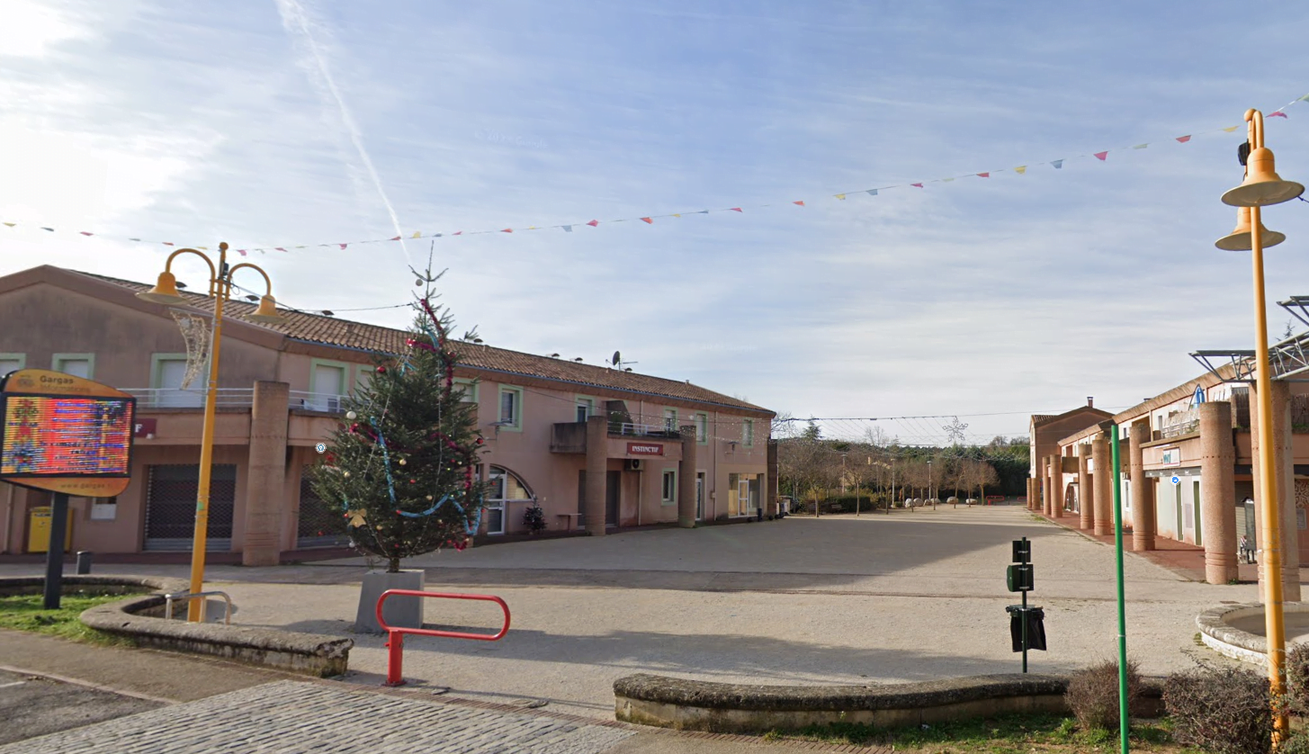Centre ville de Gargas. Place du village avec panneau d'informations.